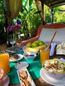 una mesa cubierta con platos de comida y fruta en El refugio de budda en Sauce de Portezuelo