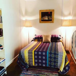 a bedroom with a bed with a colorful quilt on it at El refugio de budda in Sauce de Portezuelo