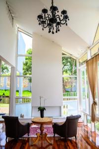 a living room with a table and chairs and windows at Feliccità Pousada in Extrema