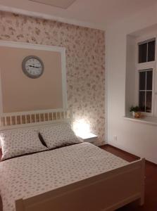 um quarto com uma cama com um relógio na parede em UBYTOVÁNÍ NA SPRÁVNÉM MÍSTĚ em Znojmo