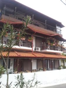 an apartment building with balconies and potted plants at Vassilis Guesthouse in Rapsáni