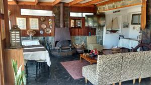 a living room with a fireplace and a couch and a table at Hotel y Cabañas La Rosa Nautica in Pichidangui