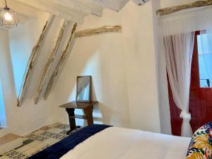 um quarto com uma cama e uma mesa com um espelho em Tinao de Las Alcántaras em Lanjarón