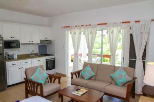 a living room with a couch and a table at Dickenson Bay Oasis at Antigua Village in Saint Johnʼs