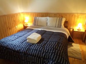 a bed with two towels sitting on top of it at Alojamiento junto al mar in Chaitén