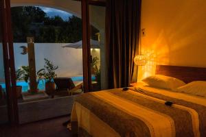 een slaapkamer met een bed en uitzicht op een patio bij Casa Beu Hotel Boutique in Puerto Escondido +57 foto's