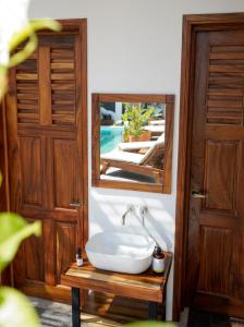 La salle de bains est pourvue d'un lavabo et d'un miroir. dans l'établissement Casa Beu, à Puerto Escondido