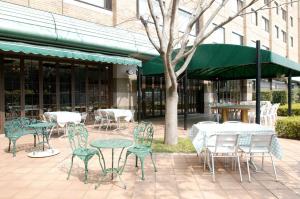 成田成田国际花园酒店的一组桌子和椅子,位于大楼前
