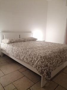 Bett in einem Schlafzimmer mit weißer Tagesdecke in der Unterkunft Whiteroom in Lecce