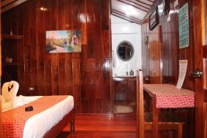 una camera con un letto e un tavolo in una barca di Theresa's Pension House a San Vicente