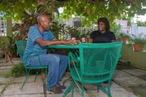 Un uomo e una donna seduti a un tavolo di Pineapple Court Hotel a Ocho Rios
