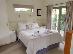 a bedroom with a bed with towels on it at Clive Colonial Cottages in Clive