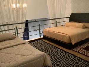 a bedroom with two beds and a railing at Kyra Luxury Duplex Studio @ Pinnacle Kelana Jaya in Kampong Baharu Sungai Way