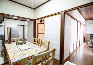 ein Esszimmer mit einem Tisch und Stühlen in der Unterkunft カビラハウス Kabira House 窓から見える川平湾まで徒歩1分 in Ishigaki-jima