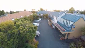 uma vista aérea de uma casa com carros estacionados numa entrada em Sherborne Motor Lodge em Christchurch