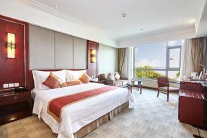 ein Hotelzimmer mit einem großen Bett und einem großen Fenster in der Unterkunft Tongli Lake View Hotel in Suzhou