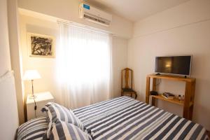 Dormitorio pequeño con cama y TV en Departamento en Belgrano en Buenos Aires