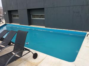 een zwembad met twee stoelen voor een gebouw bij Kalahat II in Buenos Aires