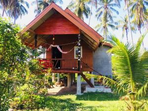 uma pequena casa com um alpendre e uma varanda em Gardenhomeresortkohjum em Ko Jum