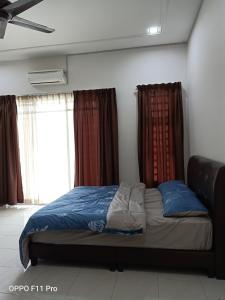 un letto in una stanza con finestre di Rara Homestay Kuala Kangsar a Kuala Kangsar