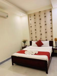 een slaapkamer met een groot bed en een rode deken bij Ha Anh Hotel - Mui Ne in Mũi Né