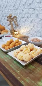 a table with three plates of cookies and other foods at Pousada Morada dos ANJOS in Penha