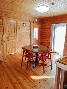 a dining room with a table and chairs in a cabin at Hakuba Powder Cottage Deep in Hakuba
