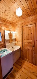 ein Holzbadezimmer mit einem Waschbecken und einem Spiegel in der Unterkunft Hakuba Powder Cottage Deep in Hakuba + 63 Fotos