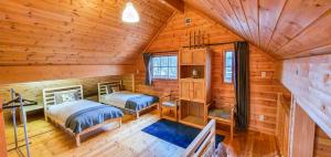 ein Schlafzimmer mit zwei Betten in einer Blockhütte in der Unterkunft Hakuba Powder Cottage Deep in Hakuba
