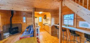 eine Küche und ein Wohnzimmer eines Blockhauses in der Unterkunft Hakuba Powder Cottage Deep in Hakuba