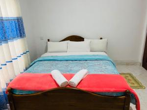 1 cama con 2 toallas blancas en una manta roja en Shiny View, en Nuwara Eliya