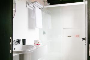 a white bathroom with a sink and a mirror at Refúgio do Cacupé in Florianópolis +105 photos