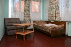 a living room with a bed and a chair and a table at Viesu nams un kempings Papes Čakstes in Pape