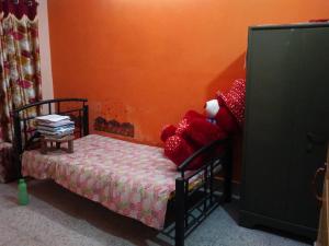 un dormitorio con una cama con animales de peluche rojos. en Pushpa Di Ghar, en Calcuta