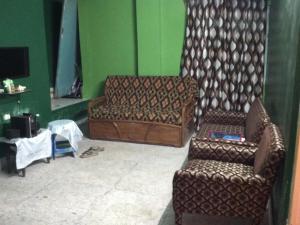 sala de estar con sofá y silla en Pushpa Di Ghar, en Calcuta