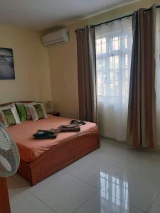 a bedroom with a bed and a large window at Twins Apartments in Flic-en-Flac