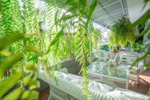 um quarto com cadeiras de vime branco e plantas em THE BEACH CHA AM Guest House em Cha Am