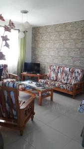 ein Wohnzimmer mit 2 Sofas und einem TV in der Unterkunft Twins Apartments in Flic-en-Flac