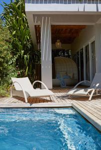 a pool with two lounge chairs next to a house at Diniview Villa Resort in Boracay