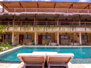 um hotel com piscina e duas cadeiras em Mango Lodge em Selong Blanak