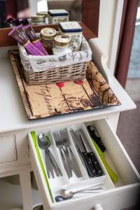 a drawer with a basket on top of a table with scissors at Brookhaven Cottage in Renwick