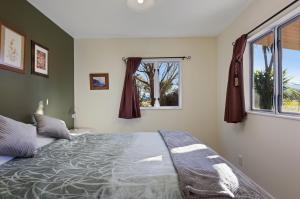 a bedroom with a large bed and a window at Brookhaven Cottage in Renwick