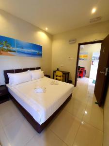a bedroom with a large white bed in a room at Amazing Rooms in Semporna +31 photos