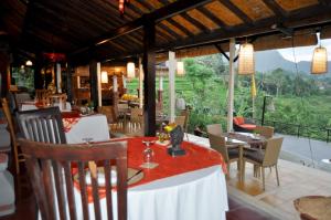 un restaurante con mesas y sillas y vistas en Subak Tabola Villa, en Sidemen