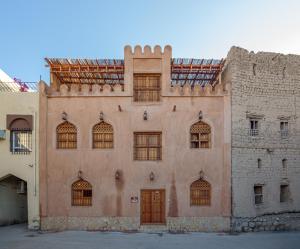 un edificio antiguo con muchas ventanas a un lado. en Nizwa Heritage Inn, en Nizwa