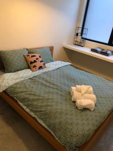een slaapkamer met een bed met 2 kussens en een raam bij Molenstraat in Dendermonde