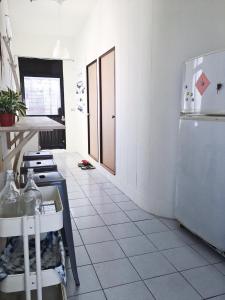 a kitchen with white tile floors and a refrigerator at Green Island Oceanrelier依海公寓 in Green Island