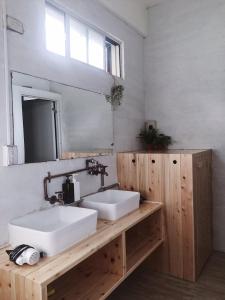 a bathroom with two white sinks and a mirror at Green Island Oceanrelier依海公寓 in Green Island