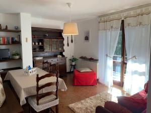 Il comprend un salon avec une table et une cuisine. dans l'établissement Bilocale Sorgente, à Ponte di Legno