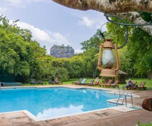 a resort with a pool and a large lantern at Sigiriya Village in Sigiriya